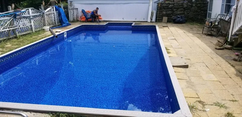 Finished blue vinyl liner in-ground pool with patio