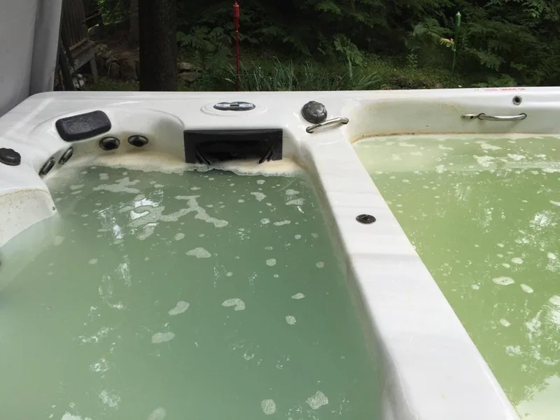 Hot tub with cloudy green water before service